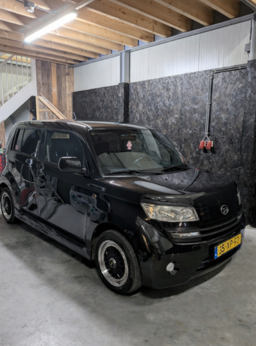 Zwarte Daihatsu Materia geparkeerd in een car detailing werkplaats